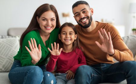 Portrait of happy family waving hands at camera