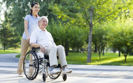 Wheelchair bound man with nursing assistant